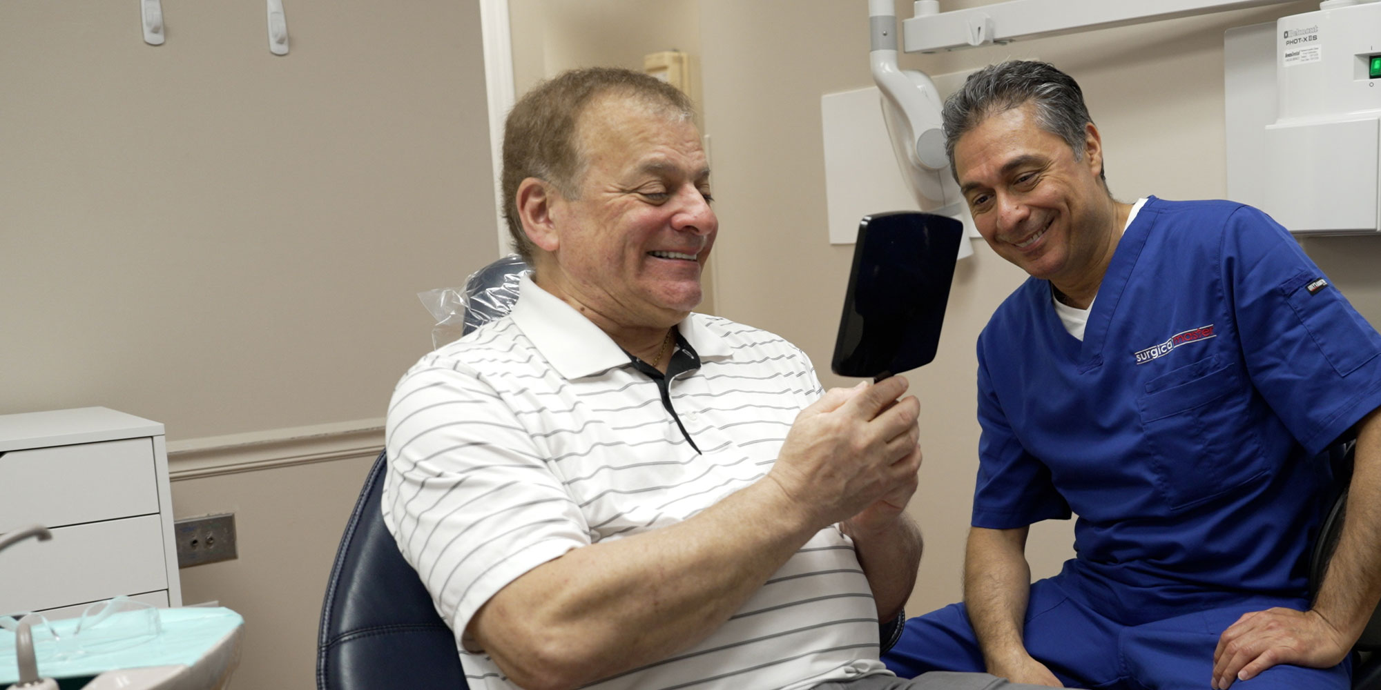 Patient looking into mirror after dental implant procedure